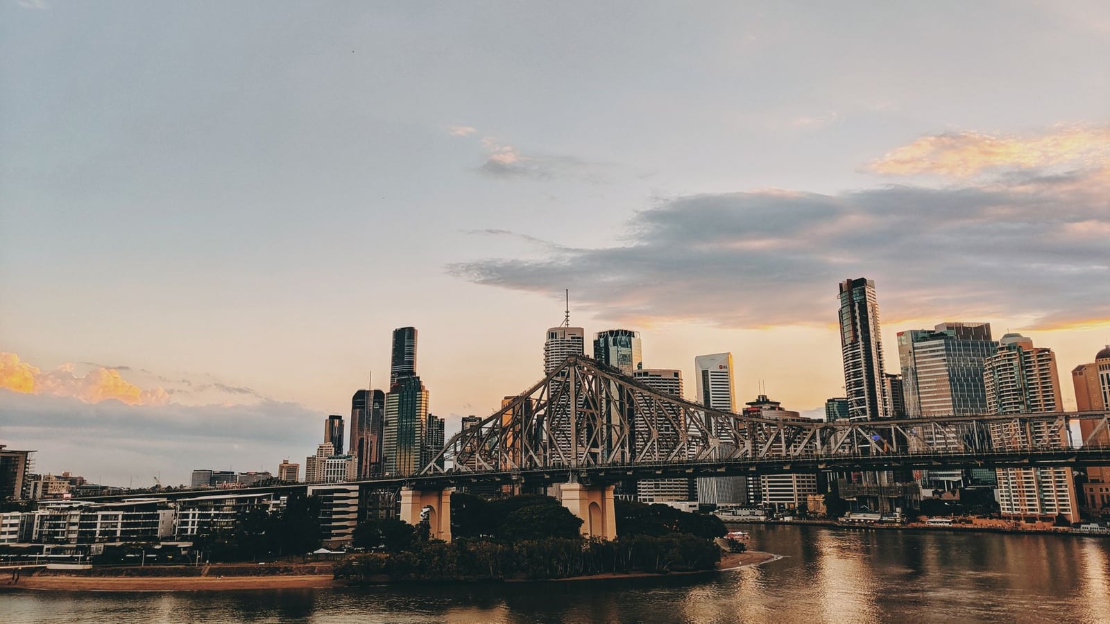 A cinematic view of the Brisbane city skyline during sunset.
