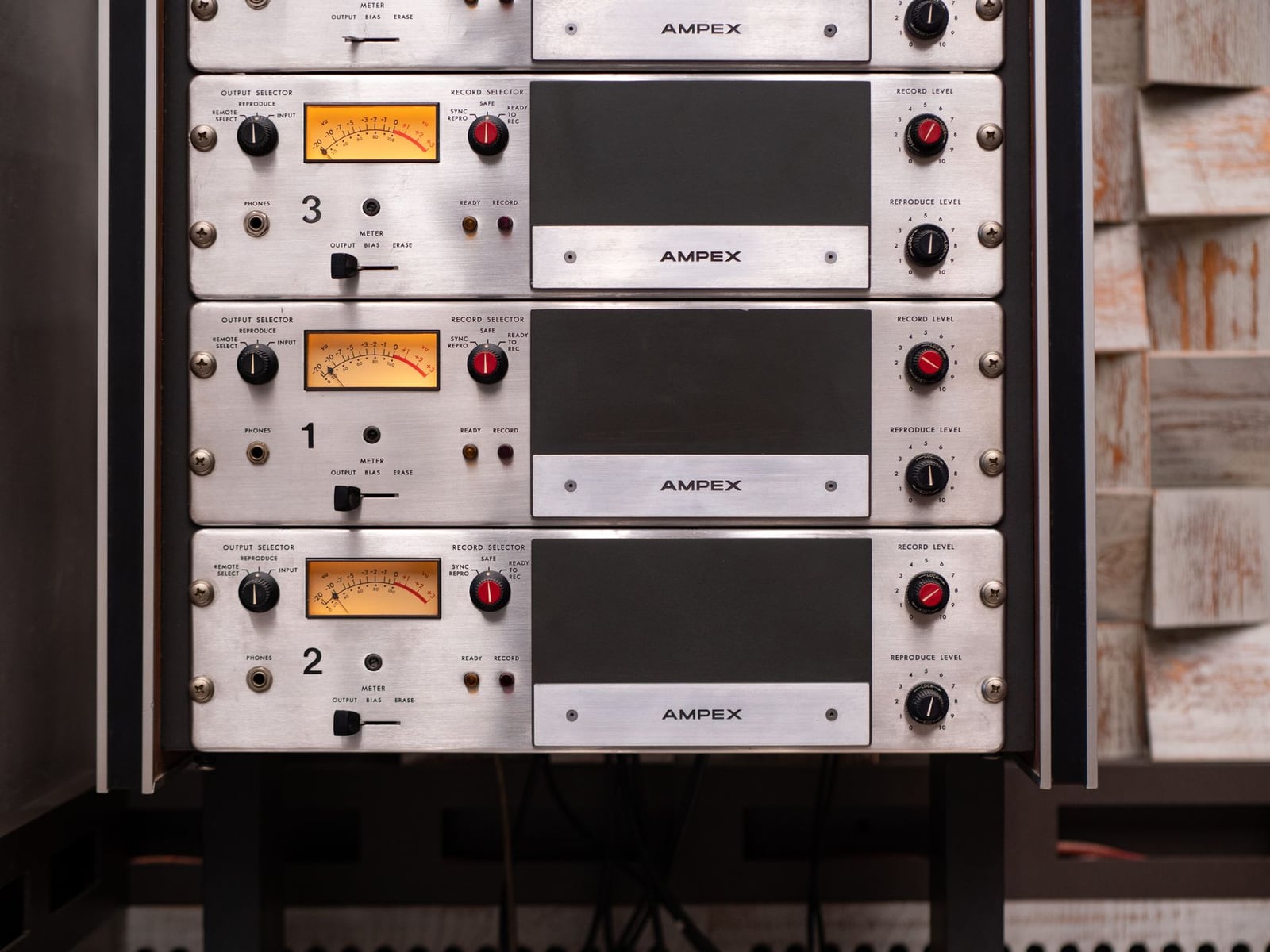 Professional analog mastering hardware with VU meters and control knobs.