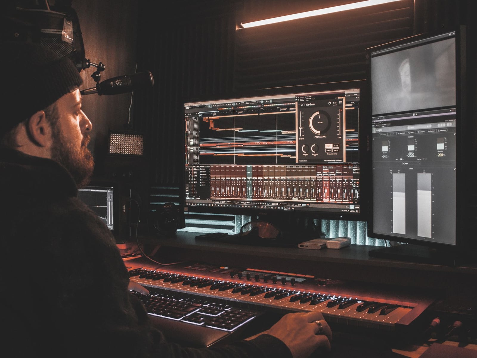 A female audio engineer wearing headphones while precisely editing vocal tracks.